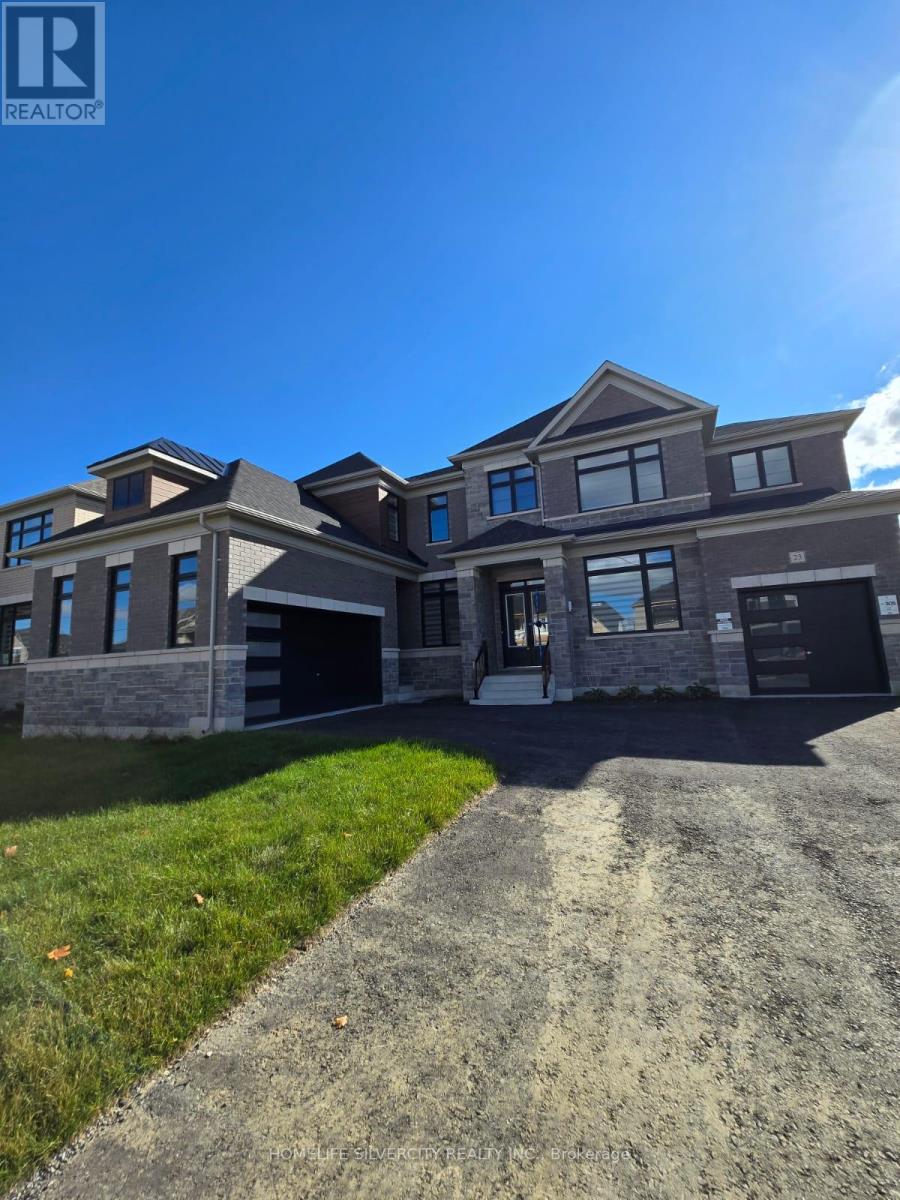 A large, modern house with a stone exterior and a driveway leading to the garage.