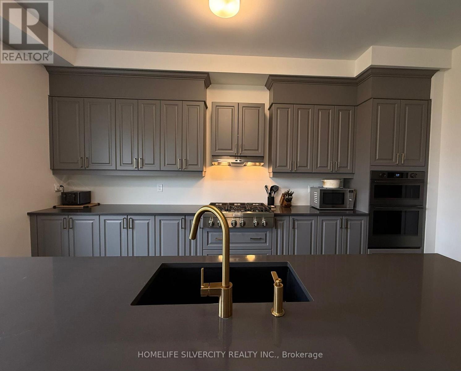 A kitchen with a black counter top and a sink.