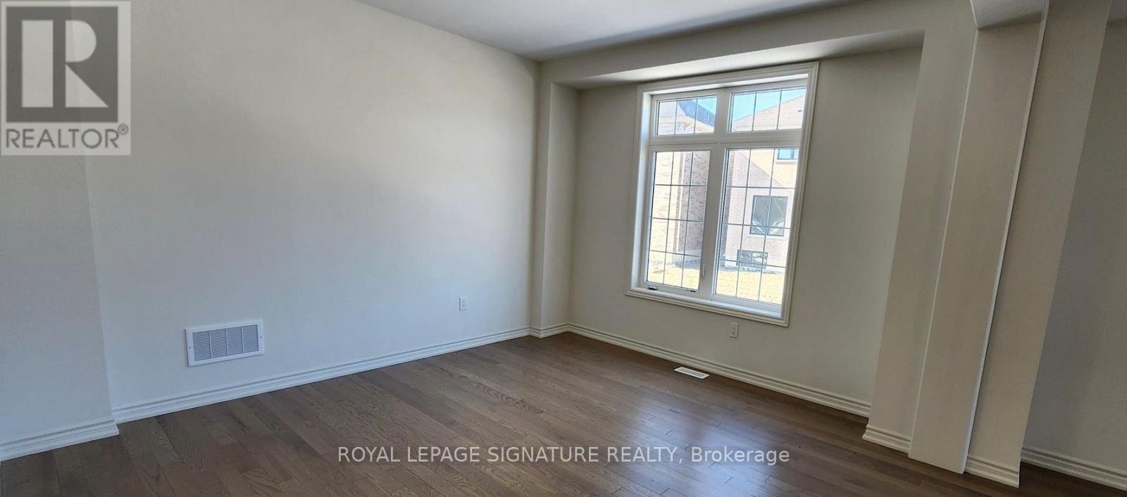 A room with a window and wooden flooring.