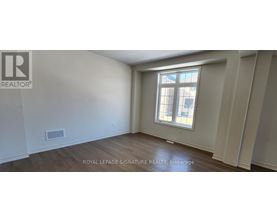 A room with a window and wooden flooring.