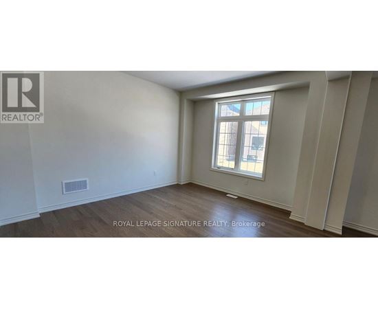 A room with a window and wooden flooring.