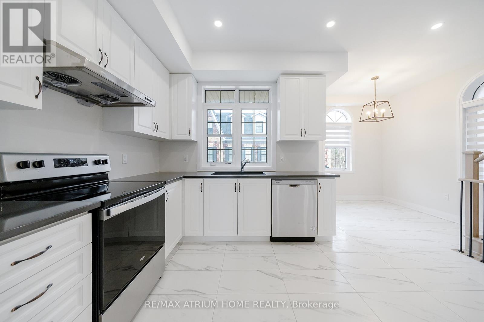 A white kitchen with a black stove top oven.