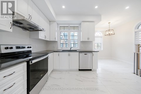 A white kitchen with a black stove top oven.