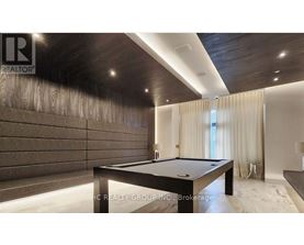 A pool table in a room with wooden walls and a carpeted floor.