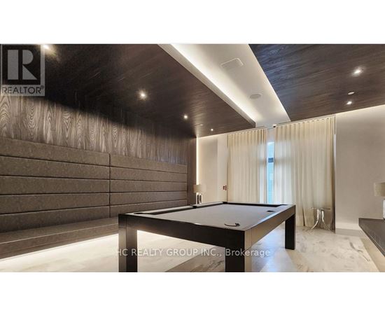 A pool table in a room with wooden walls and a carpeted floor.