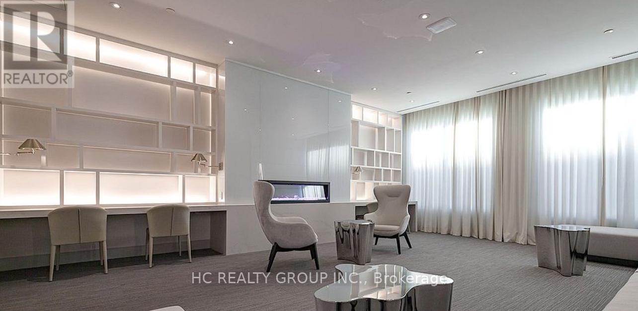 A modern office space with a glass wall and a desk with a chair.