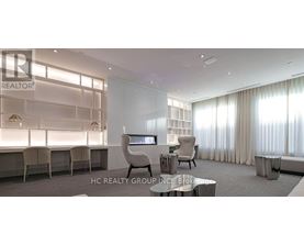 A modern office space with a glass wall and a desk with a chair.