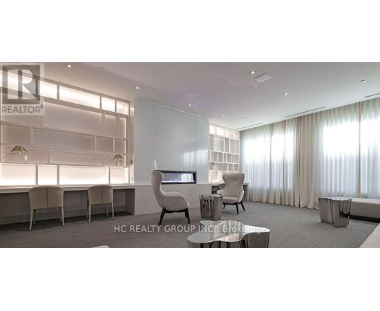 A modern office space with a glass wall and a desk with a chair.