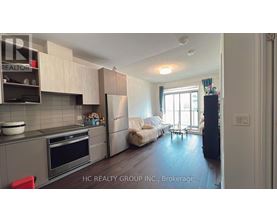 A kitchen with a refrigerator, oven, and sink.