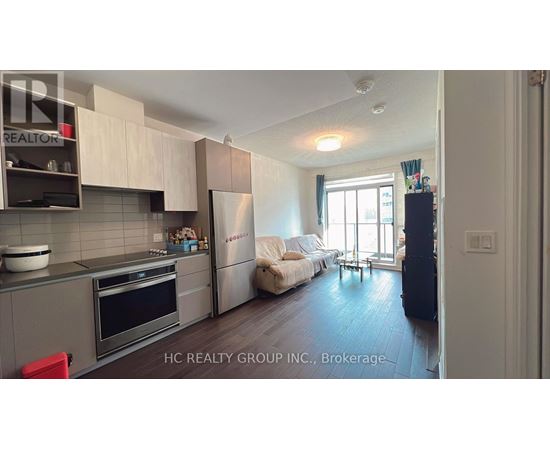 A kitchen with a refrigerator, oven, and sink.