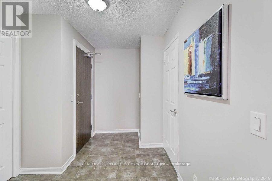 A hallway with a painting on the wall and a door on the left.