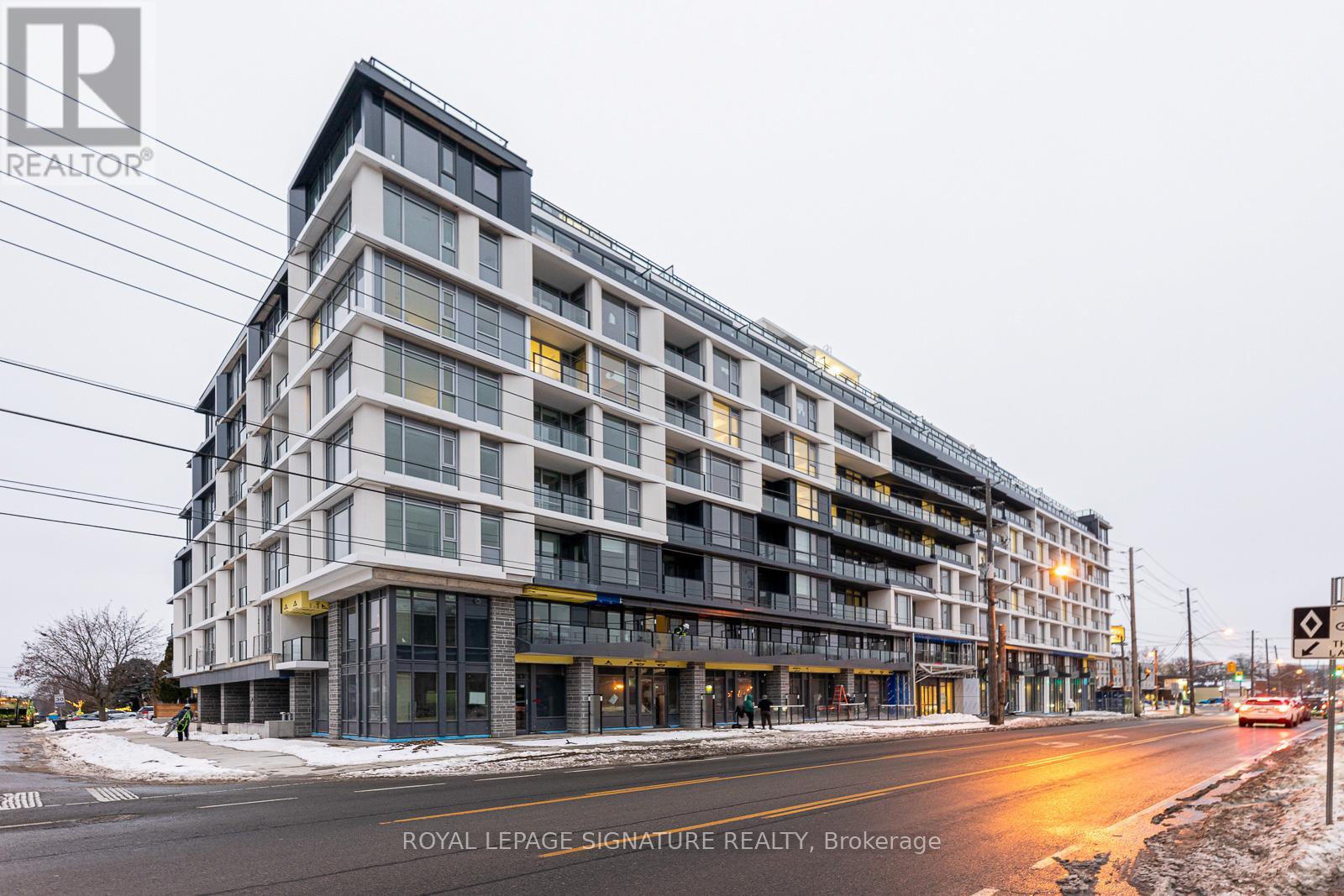 A large, modern building with many windows is the main focus of the image.
