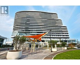 A modern building with a curved facade and a bright orange canopy in front.