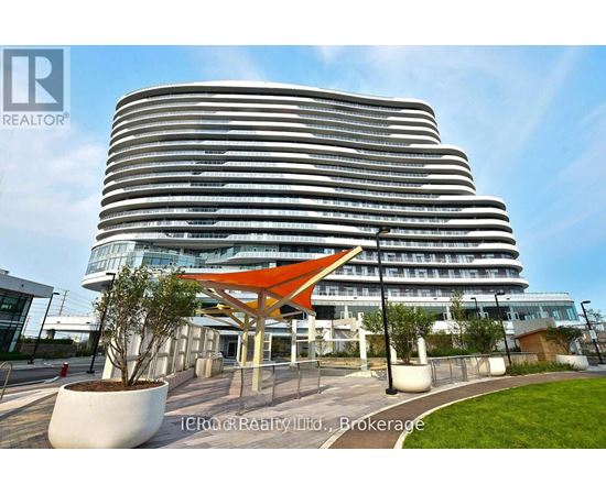 A modern building with a curved facade and a bright orange canopy in front.