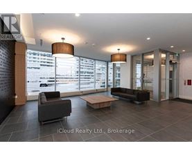 A modern lobby with a black couch and a wooden coffee table.