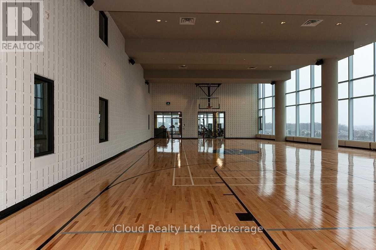 A spacious room with wooden floors and large windows.