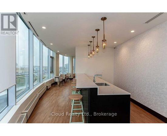 A modern kitchen with a long counter and bar stools.