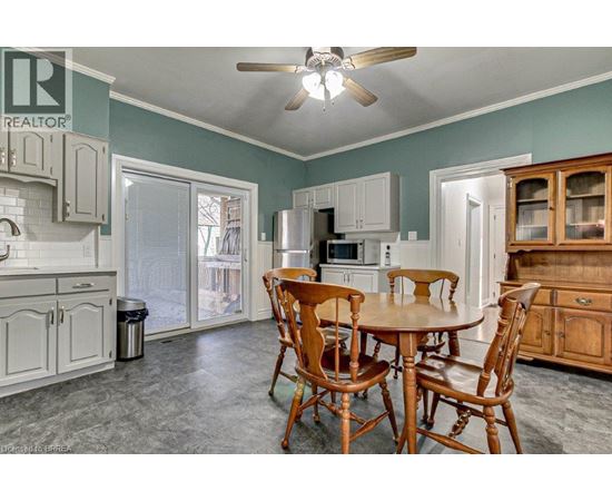 A dining room with a table and chairs.