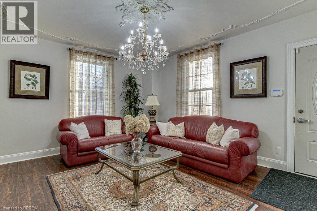 A living room with red couches and a chandelier.