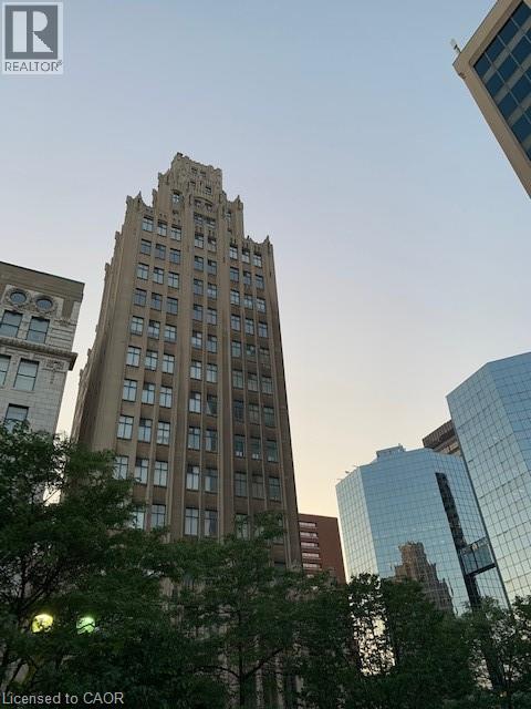 A tall building with many windows stands in front of other buildings.