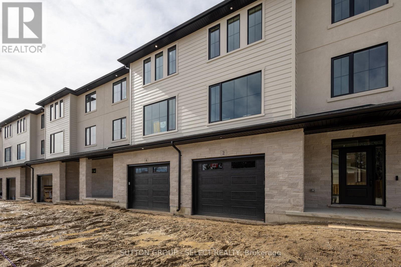 A row of new houses with garages are for sale.