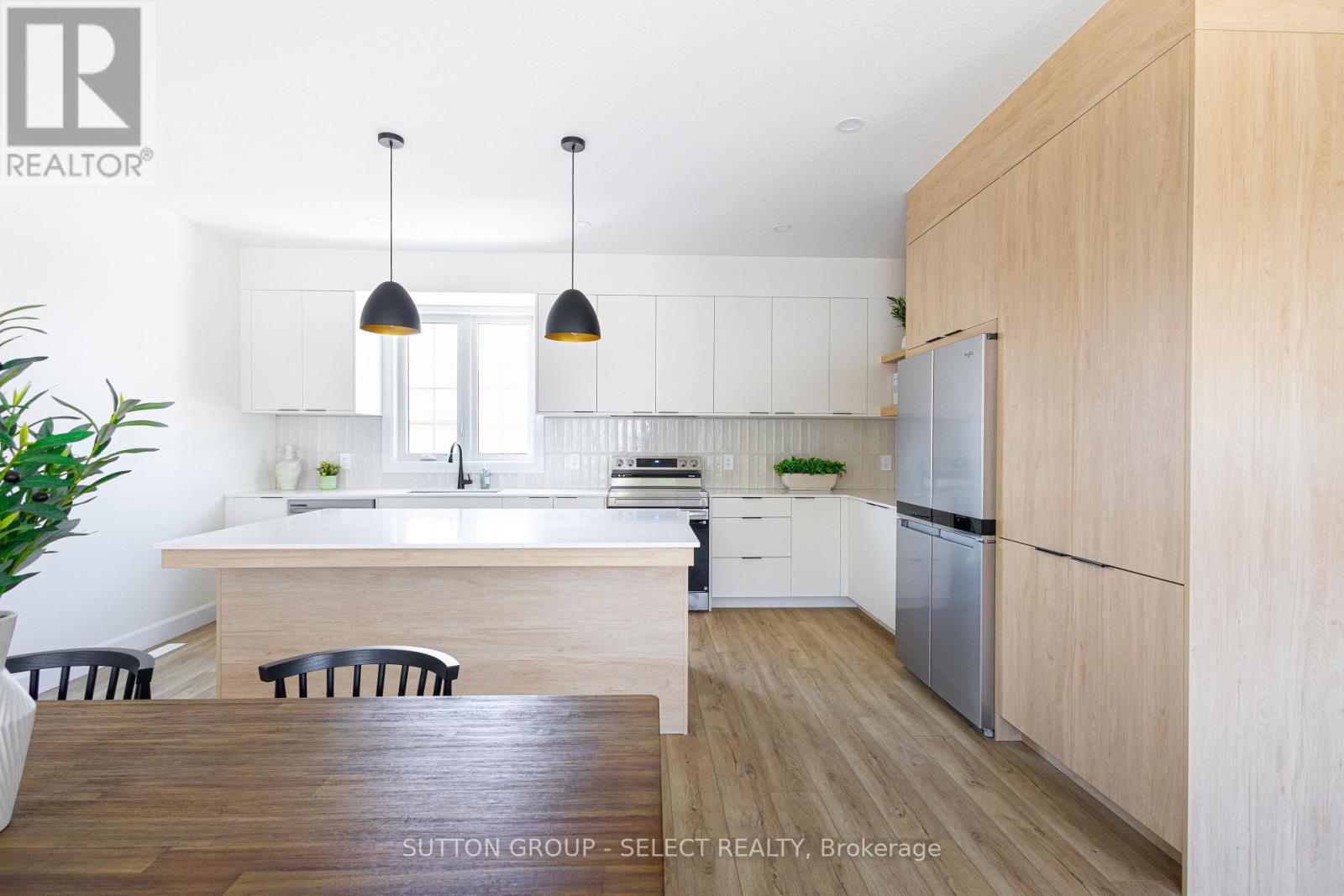 A modern kitchen with a wooden table and chairs.