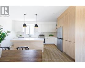 A modern kitchen with a wooden table and chairs.