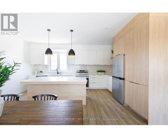 A modern kitchen with a wooden table and chairs.