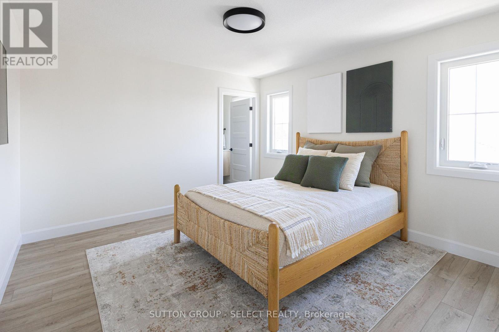 A bedroom with a bed, rug, and a window.