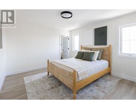 A bedroom with a bed, rug, and a window.