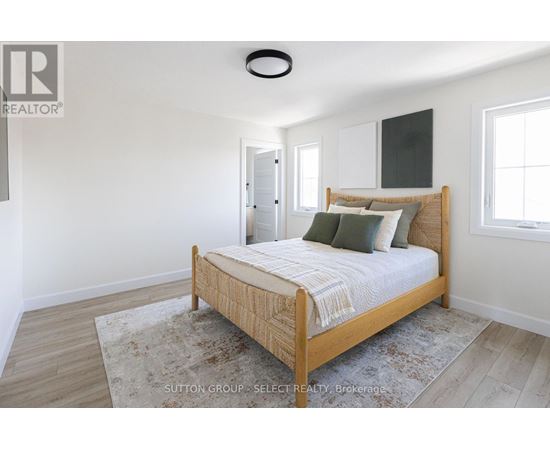 A bedroom with a bed, rug, and a window.