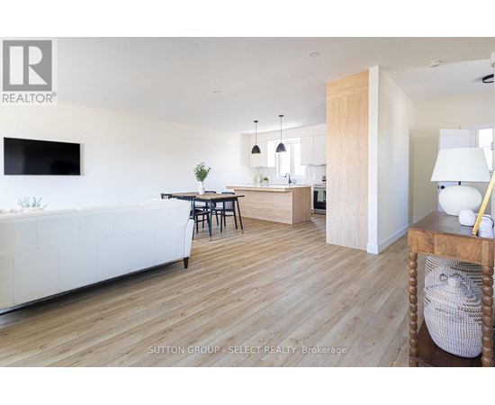 A living room with a white couch and a television on the wall.