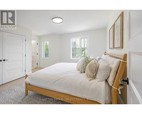A bedroom with a bed, pillows, and a window.