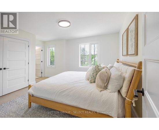 A bedroom with a bed, pillows, and a window.