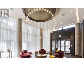 A reception area with a chandelier, red chairs, and a sign that says "HOMELESS LANDMARK REALTY INC Brokerage".