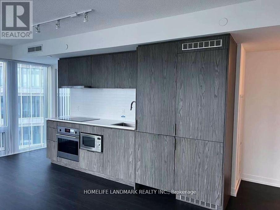 A modern kitchen with wooden cabinets and a stainless steel oven.