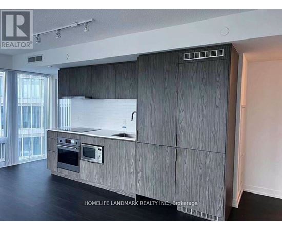 A modern kitchen with wooden cabinets and a stainless steel oven.