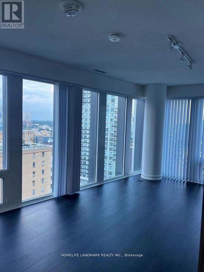 A spacious room with large windows overlooking a cityscape.