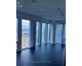 A spacious room with large windows overlooking a cityscape.