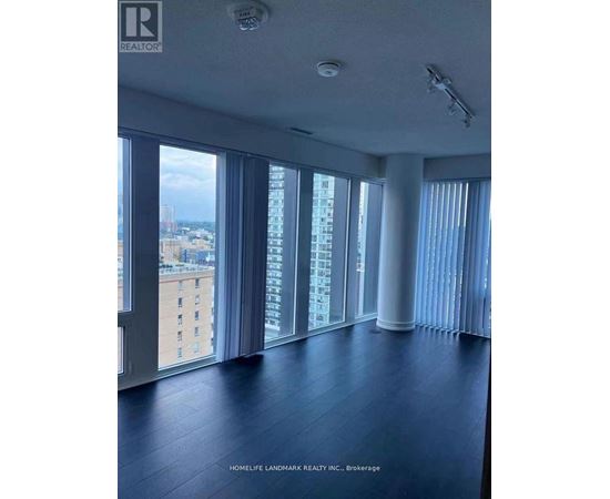 A spacious room with large windows overlooking a cityscape.