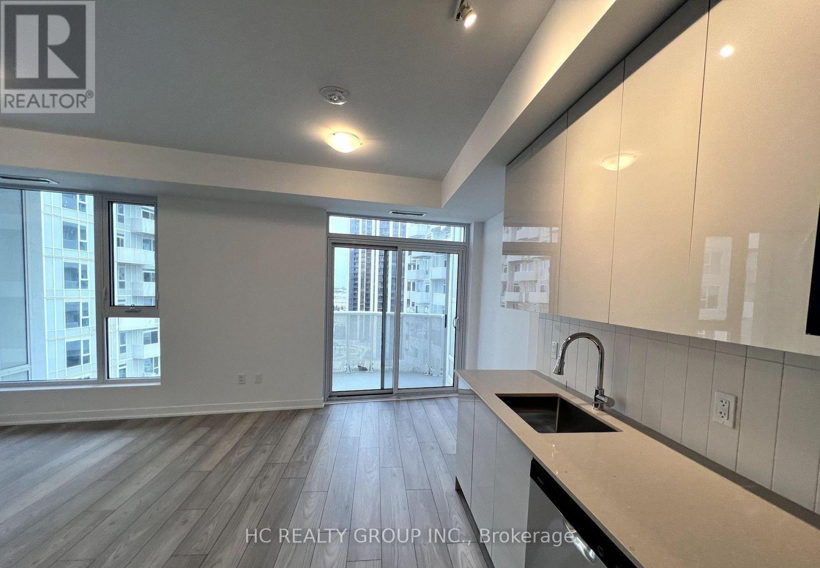 A kitchen with a sink and a window overlooking a city.