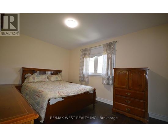 A bedroom with a bed, dresser, and window.