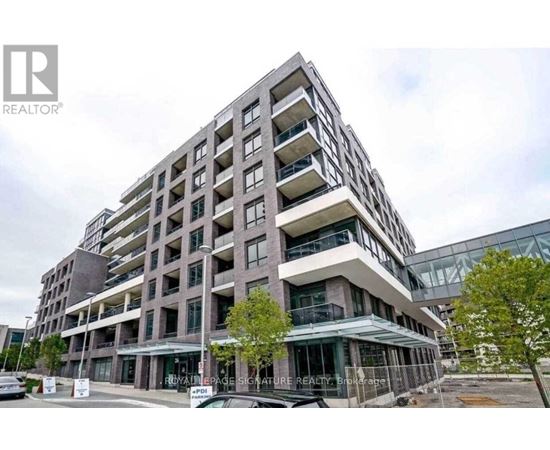 A modern multi-story building with a glass facade and balconies.