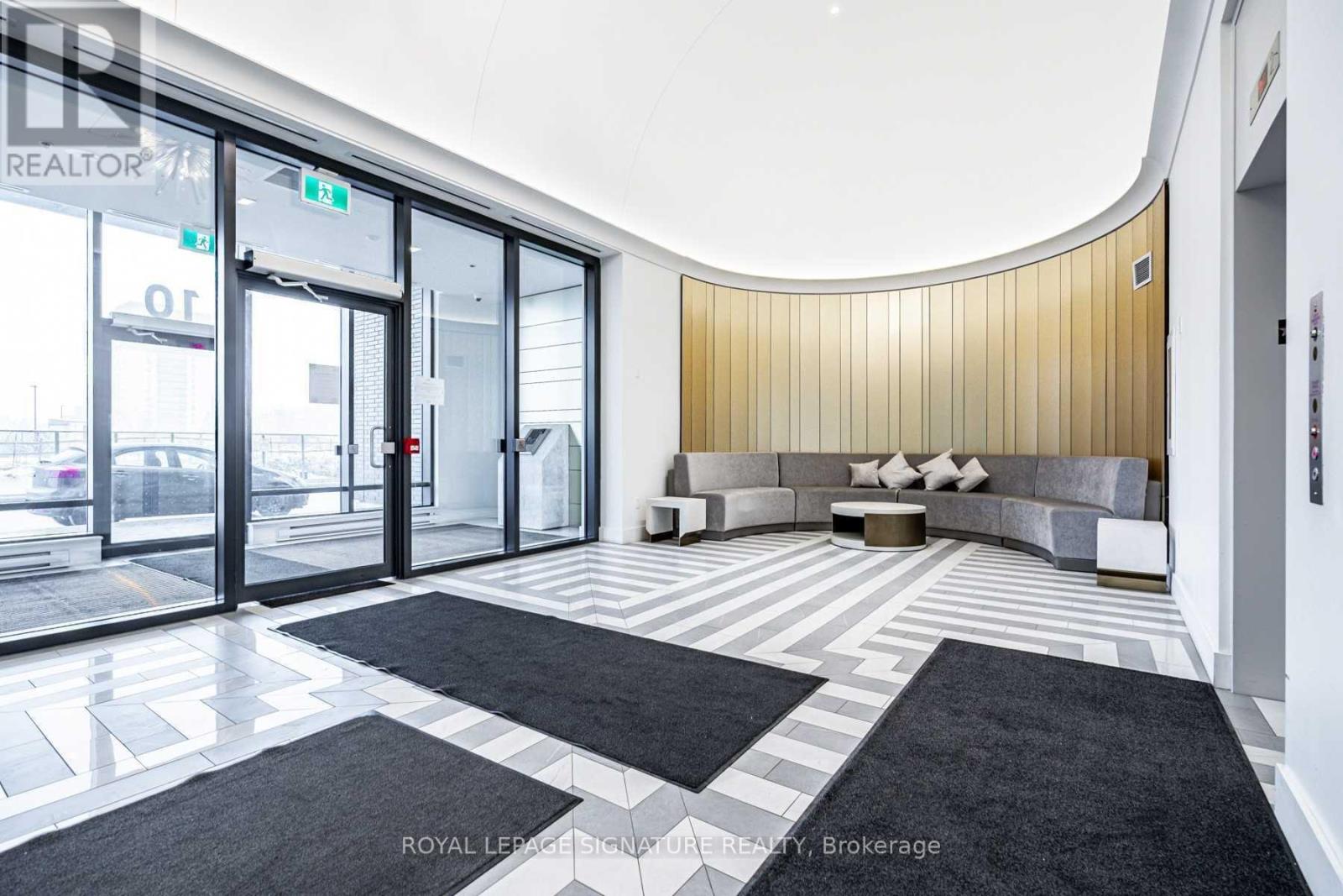 A modern office lobby with a curved wall and a bench.