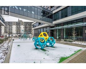 A playground with a blue and yellow structure in the middle of a snowy courtyard.