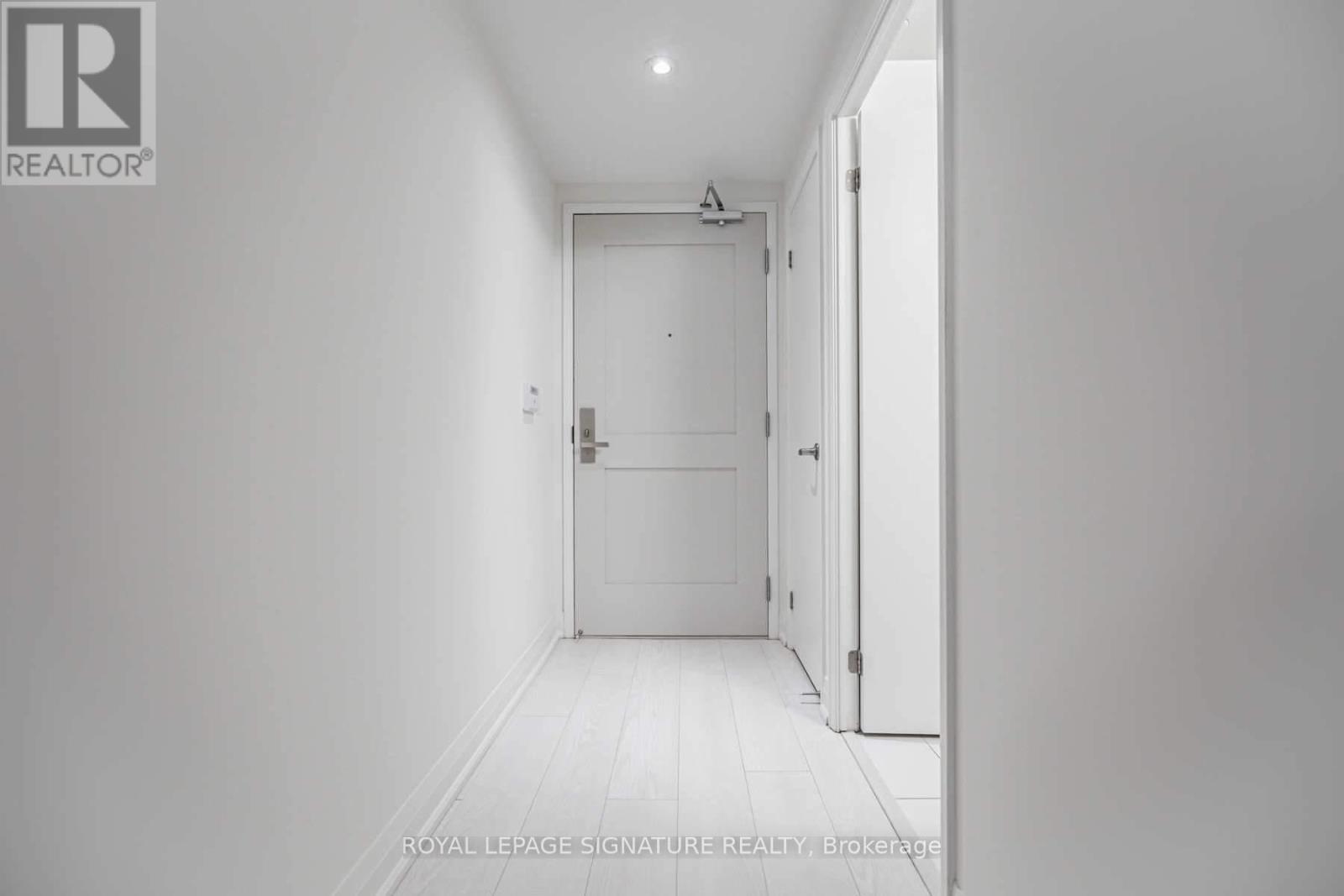 A white hallway with a door on the right.