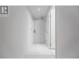 A white hallway with a door on the right.