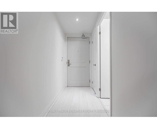 A white hallway with a door on the right.
