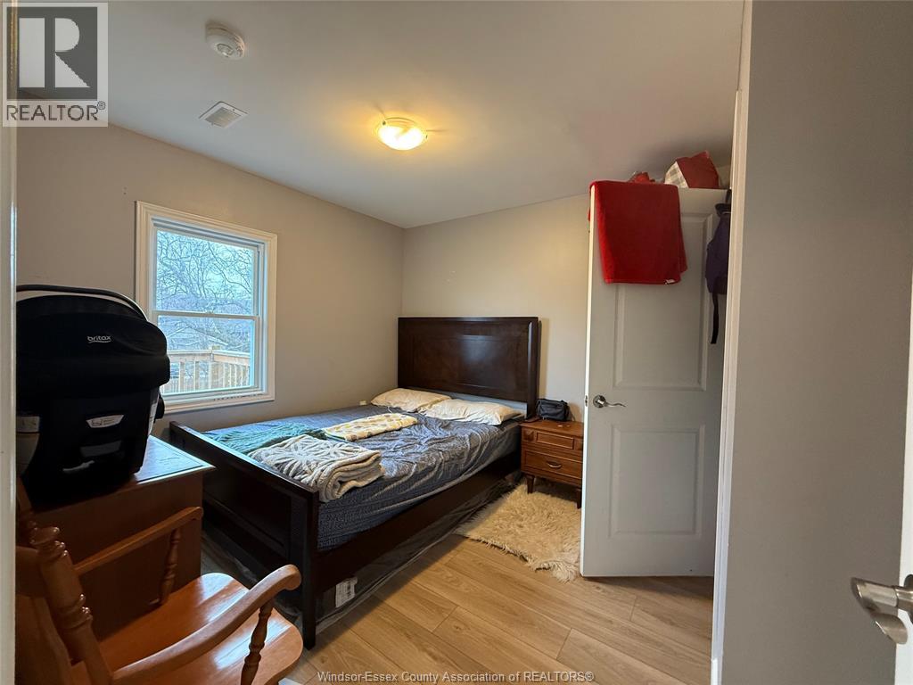 A bedroom with a bed, dresser, and chair.
