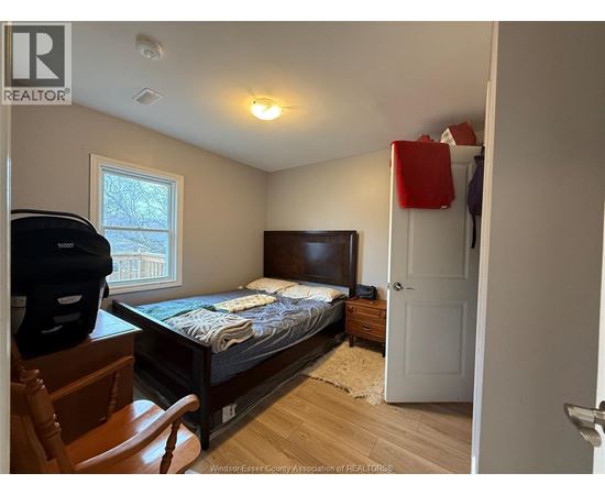A bedroom with a bed, dresser, and chair.